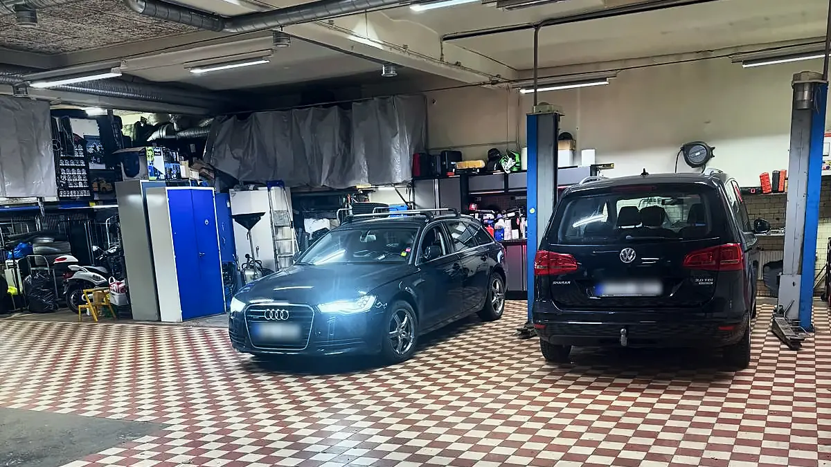 Verkstadsgolvet hos Norrtull Bil & Motor med två bilar inne för service under lysrörsbelysning